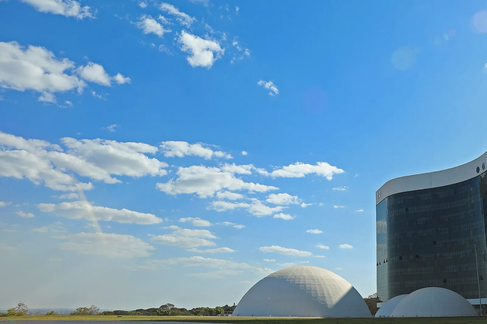 Prédio do Tribunal Superior Eleitoral, em Brasília, sob céu azul, com cúpulas brancas em primeiro plano.