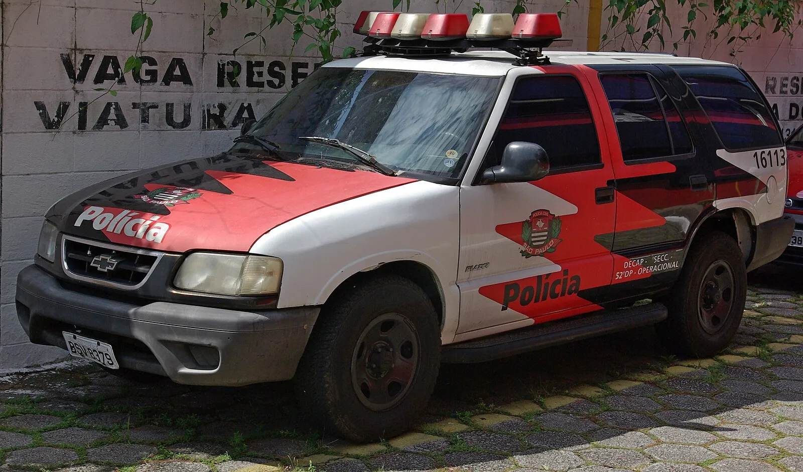 Viatura vermelha e branca da Polícia Civil de São Paulo estacionada.