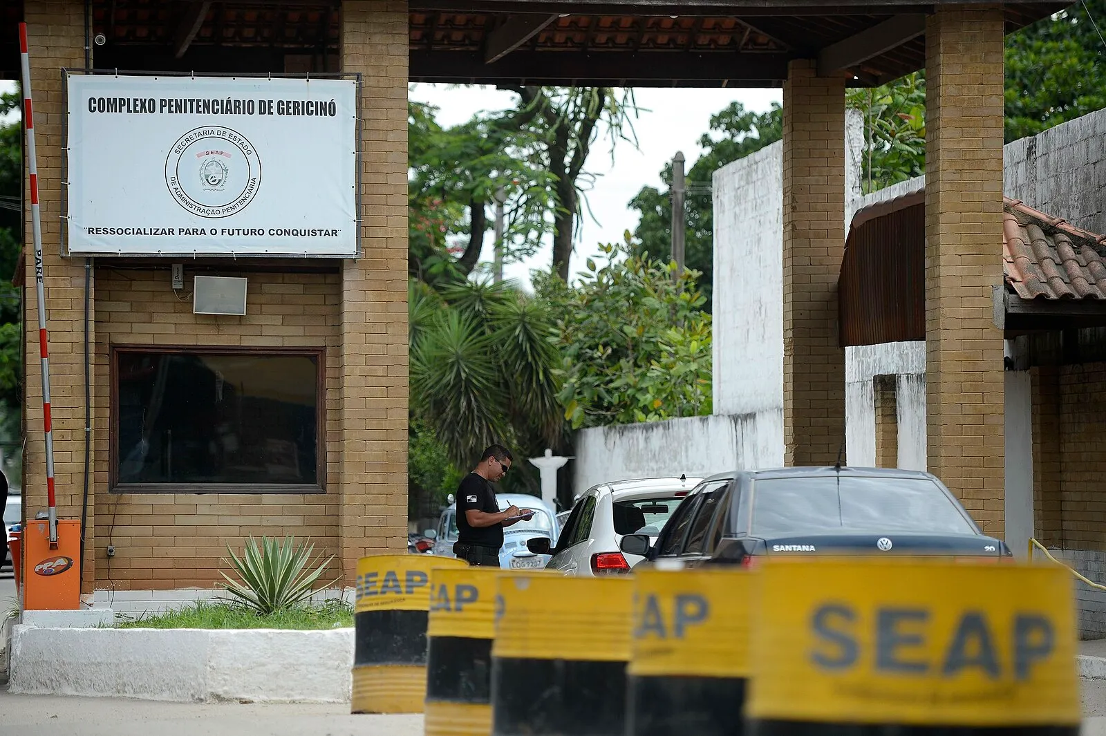 Entrada do Complexo Penitenciário de Gericinó com placa de identificação e barreiras.