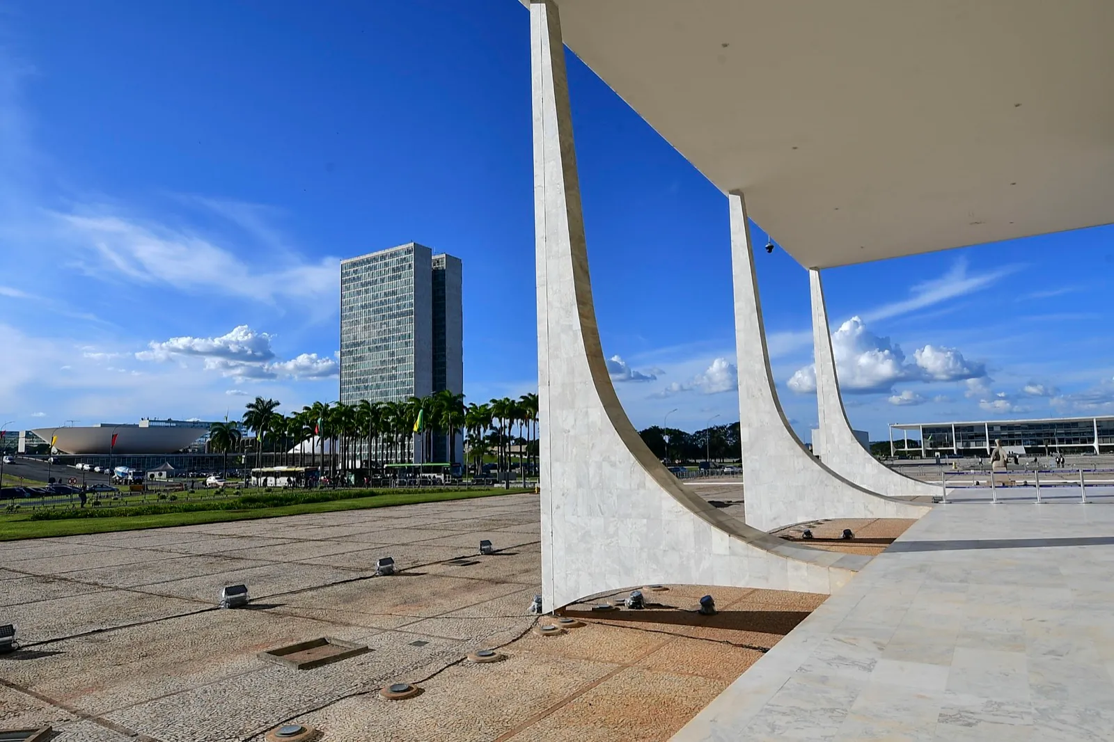 Fachada do Supremo Tribunal Federal, em Brasília, com grandes colunas curvas de mármore branco sob céu azul.